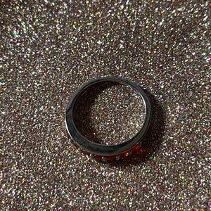 Sterling silver ring with orange stones on the front half.